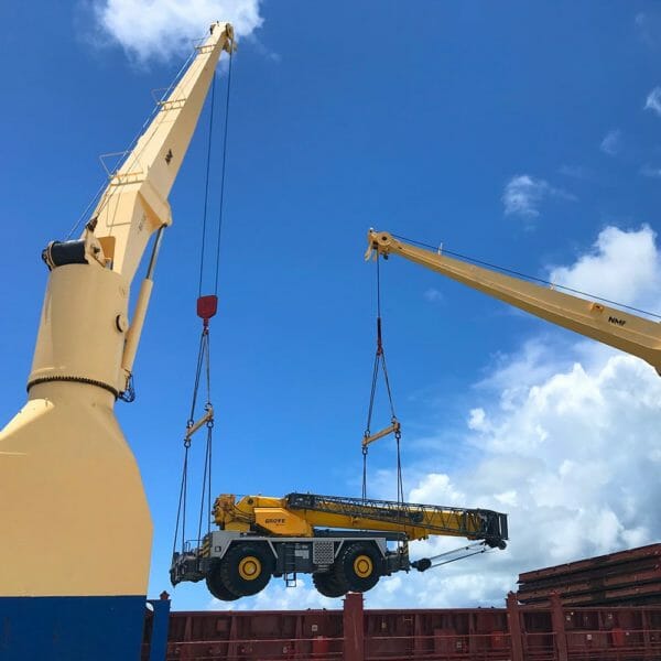 ship cranes lifting crane off of a boat